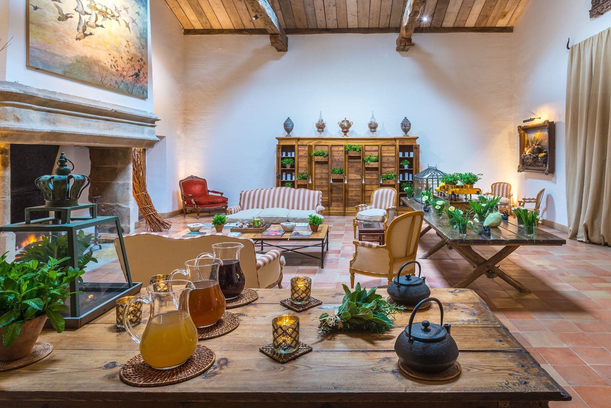 The thermal-spa welcome lounge under exposed beams, fireplace lit and tisanes laid on a country table.