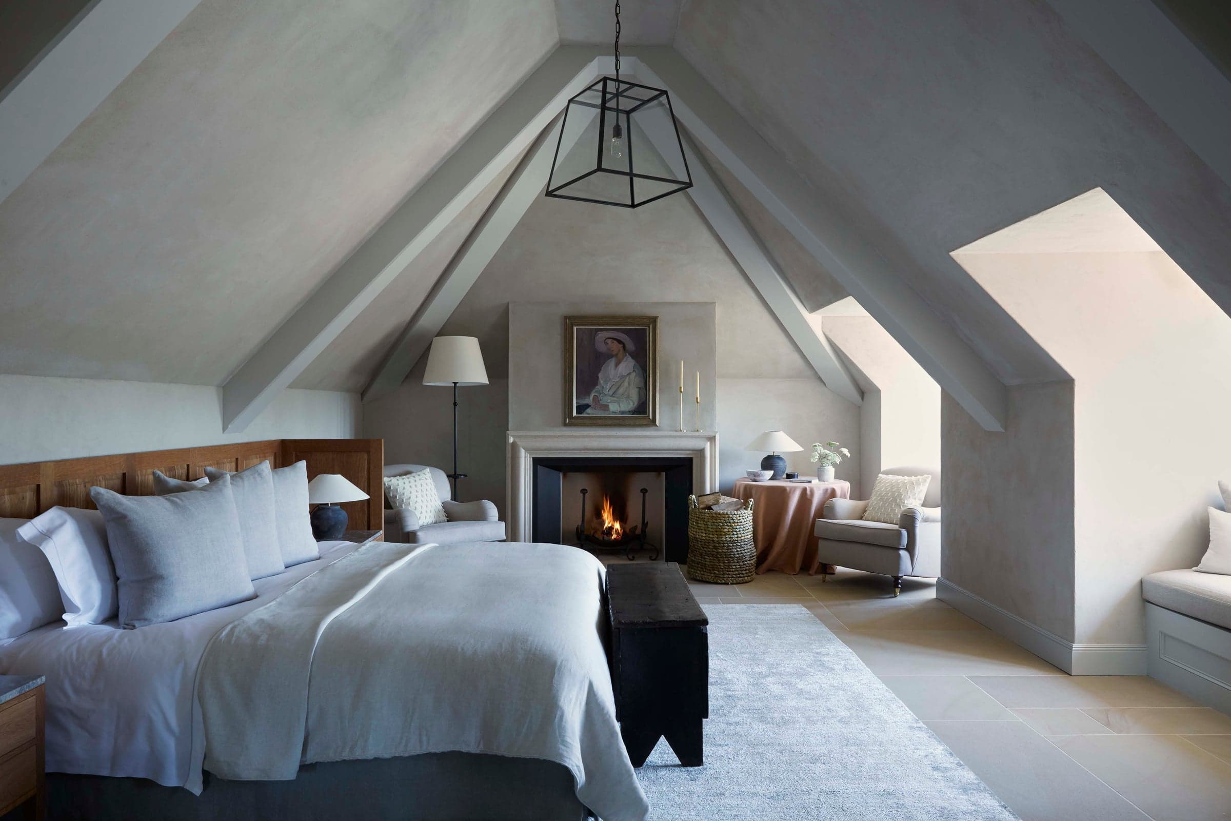 The Long Room signature suite, a quiet bedroom in pale tones with a long window onto the garden.