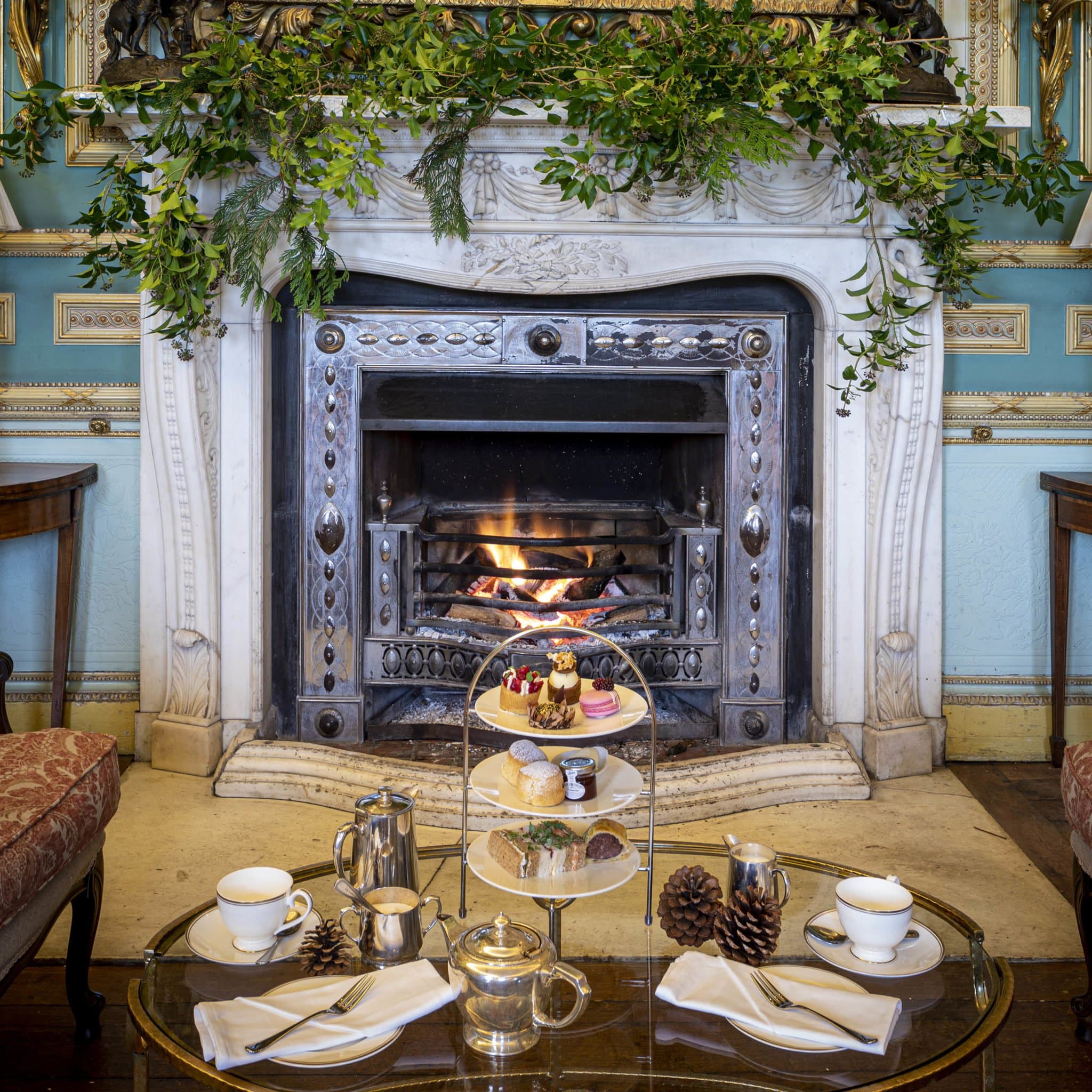 Afternoon tea taken by the fire at Swinton Park, scones and silver on linen with the hearth burning behind.