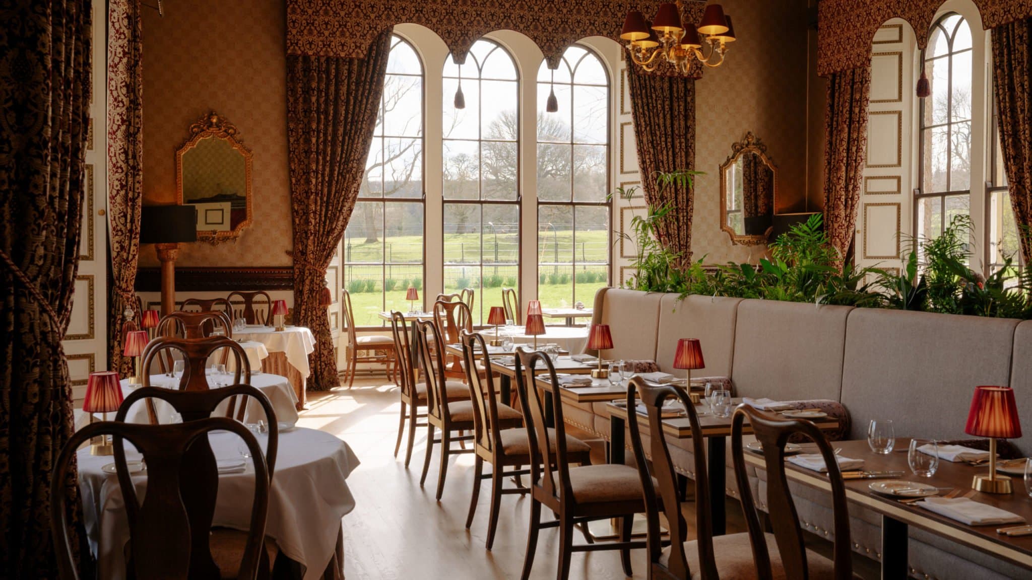 The dining room at Samuel's, panelled walls and pale linen under the warm light of a chandelier.